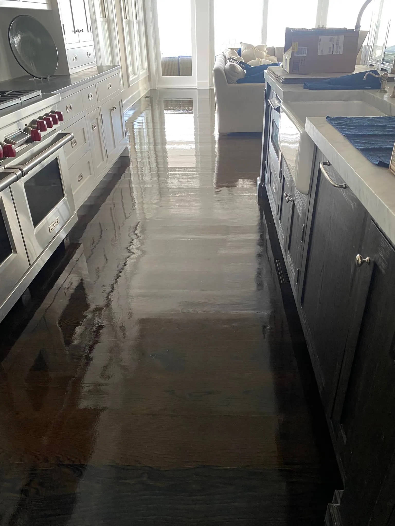 Long view down a kitchen aisle showing the wet look of the new glossy wood floor finish.